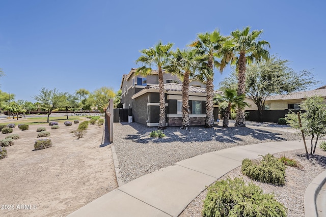 view of front of home featuring fence, stucco siding, and a tile roof