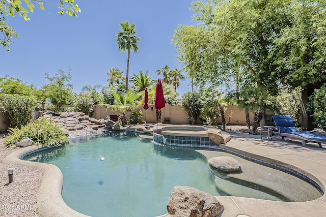 view of swimming pool with a fenced backyard, a patio area, and a pool with connected hot tub
