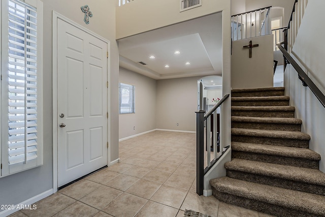 foyer entrance with visible vents, stairs, and light tile patterned floors