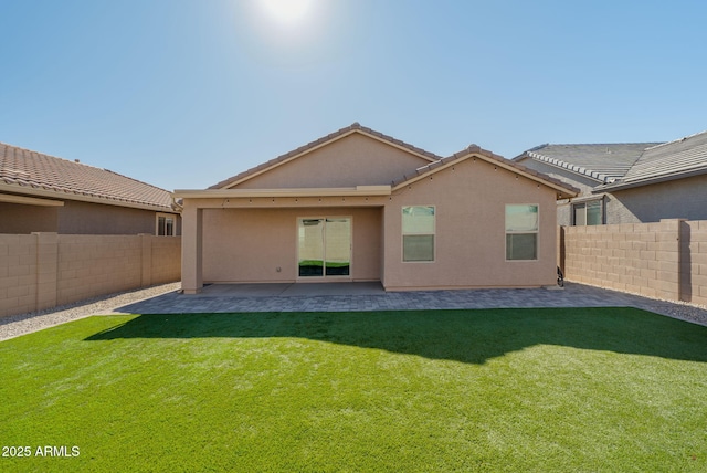 rear view of property with a yard and a patio area