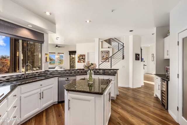 kitchen featuring wine cooler, dark stone counters, white cabinets, a center island, and dishwasher