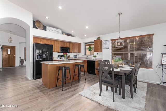 dining room with lofted ceiling and light hardwood / wood-style floors