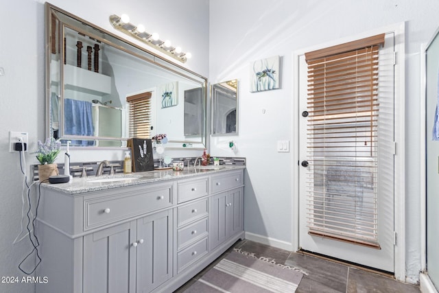 bathroom featuring a shower with door and vanity