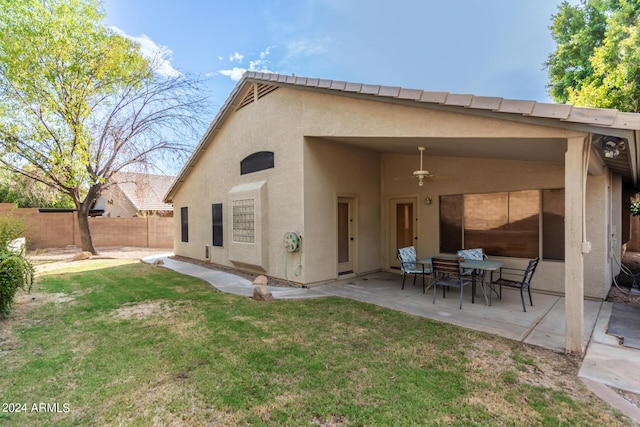 rear view of house with a patio area, ceiling fan, and a lawn