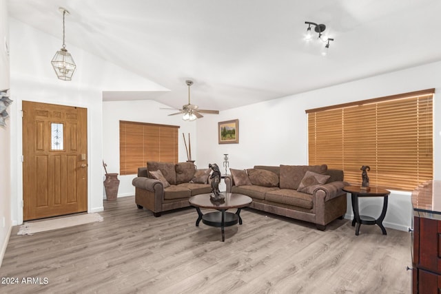 living room with light hardwood / wood-style flooring, ceiling fan, and vaulted ceiling