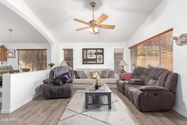 living room featuring ceiling fan, plenty of natural light, vaulted ceiling, and light hardwood / wood-style flooring