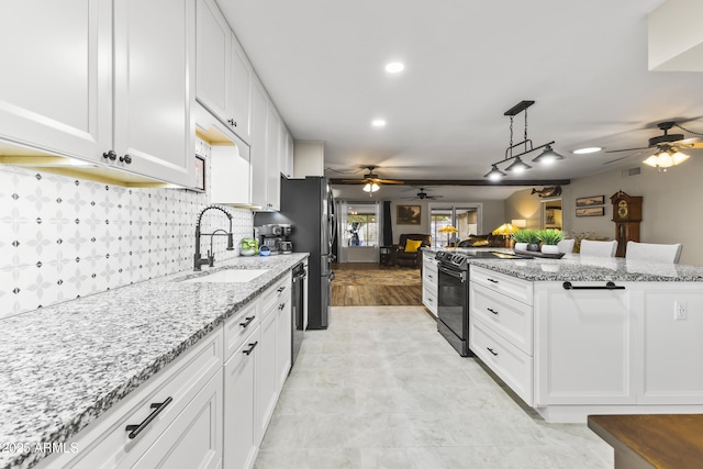 kitchen featuring light stone countertops, white cabinetry, sink, and stainless steel appliances