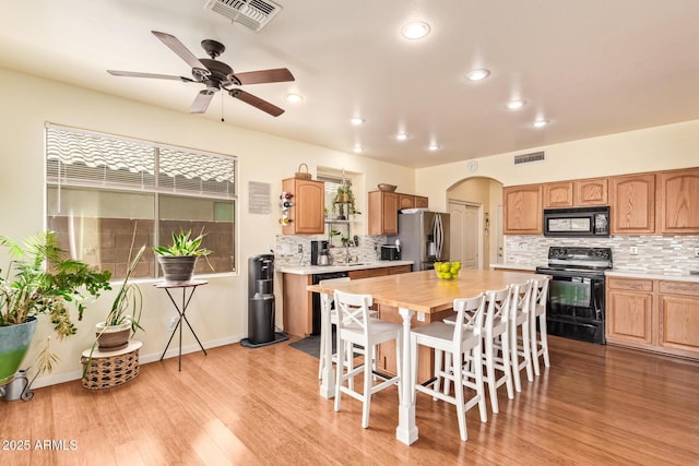 30013 N Candlewood Dr, San Tan Valley, AZ 85143 - kitchen featuring light wood-type flooring, arched walkways, black appliances, and visible vents