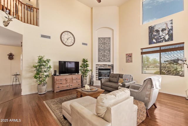 30013 N Candlewood Dr, San Tan Valley, AZ 85143 - living room with a tiled fireplace, wood finished floors, a towering ceiling, and visible vents