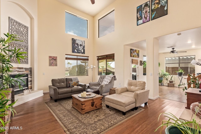 30013 N Candlewood Dr, San Tan Valley, AZ 85143 - living area with a stone fireplace, a ceiling fan, a towering ceiling, and wood finished floors