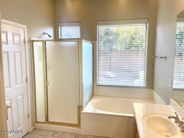 bathroom featuring a healthy amount of sunlight, plus walk in shower, tile patterned flooring, and vanity