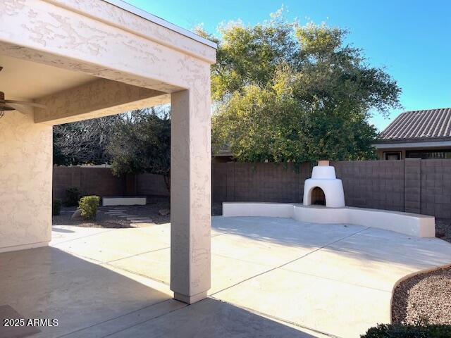 view of patio featuring ceiling fan and an outdoor fireplace