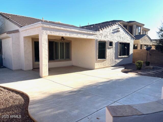 rear view of property featuring a patio and ceiling fan