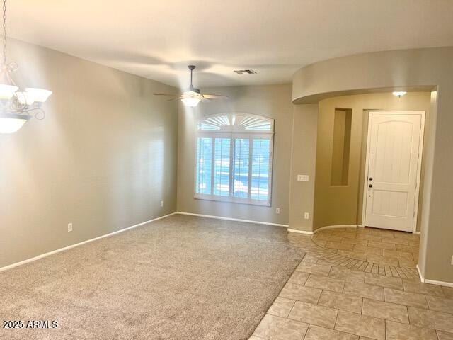 spare room with ceiling fan with notable chandelier and light colored carpet