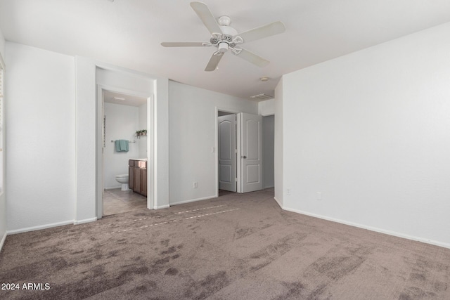 unfurnished bedroom with ceiling fan, light carpet, and ensuite bath