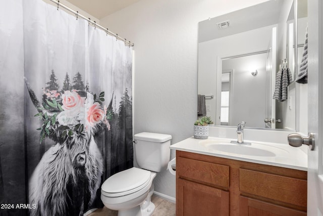 bathroom with tile patterned flooring, vanity, and toilet