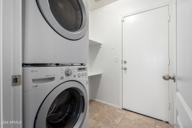 laundry room with stacked washer / drying machine and light tile patterned floors