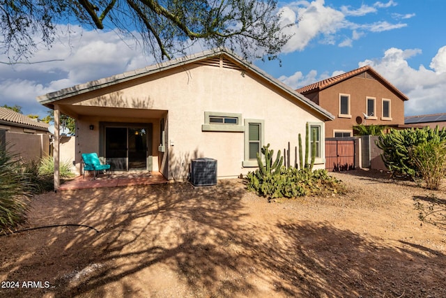 rear view of property featuring a patio and central AC