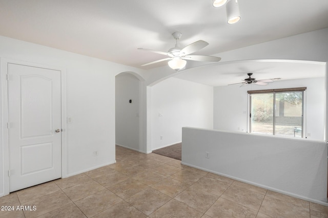 empty room with ceiling fan and light tile patterned floors