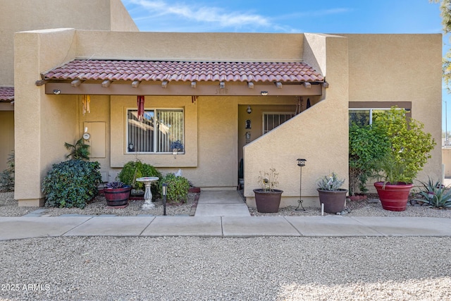 exterior space featuring a tile roof and stucco siding