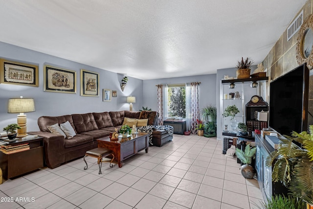 living room featuring a textured ceiling, light tile patterned flooring, and visible vents