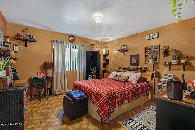 bedroom with a textured ceiling and a textured wall