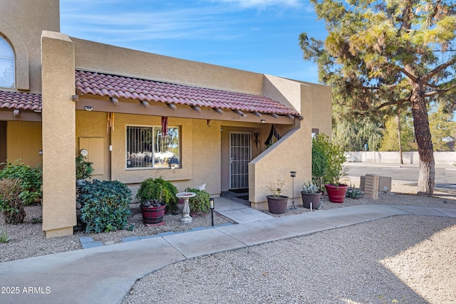 view of front facade featuring a tile roof and stucco siding