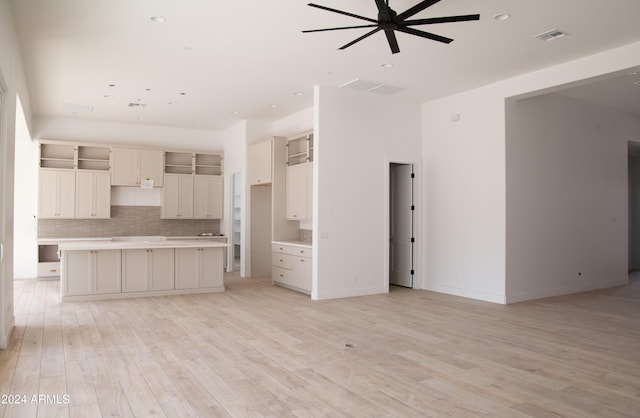 kitchen with tasteful backsplash, light hardwood / wood-style flooring, a kitchen island, and ceiling fan