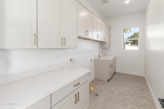 washroom featuring sink, washer hookup, hookup for an electric dryer, and cabinets