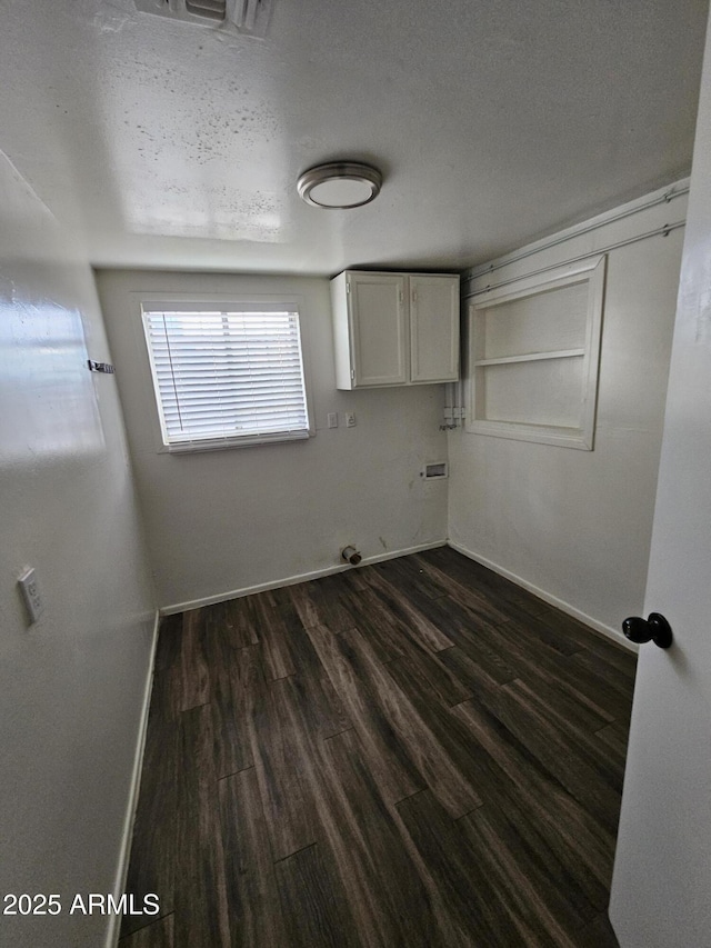 empty room featuring dark hardwood / wood-style floors and a textured ceiling