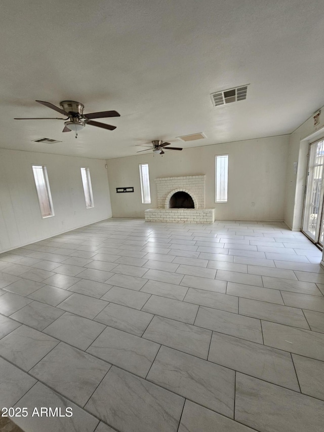 unfurnished living room featuring a fireplace and ceiling fan