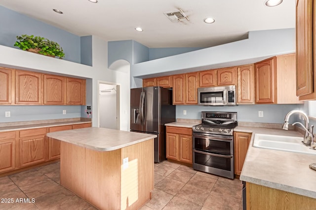 kitchen with a center island, high vaulted ceiling, sink, light tile patterned floors, and stainless steel appliances