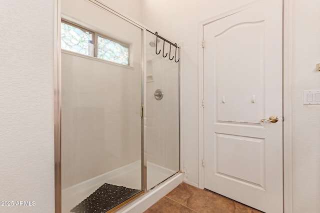 bathroom featuring tile patterned floors and a shower with shower door