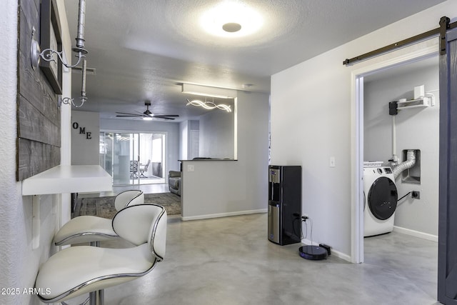 interior space featuring washer / dryer, a barn door, a textured ceiling, and ceiling fan