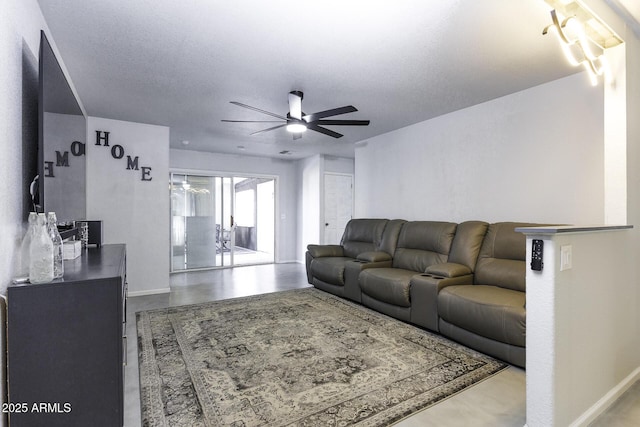 living room featuring ceiling fan, concrete flooring, and a textured ceiling