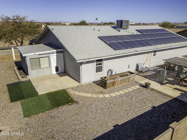 rear view of house with solar panels and central AC