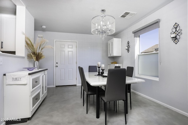 dining area featuring concrete floors and a notable chandelier