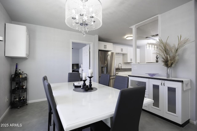 dining area with sink and an inviting chandelier