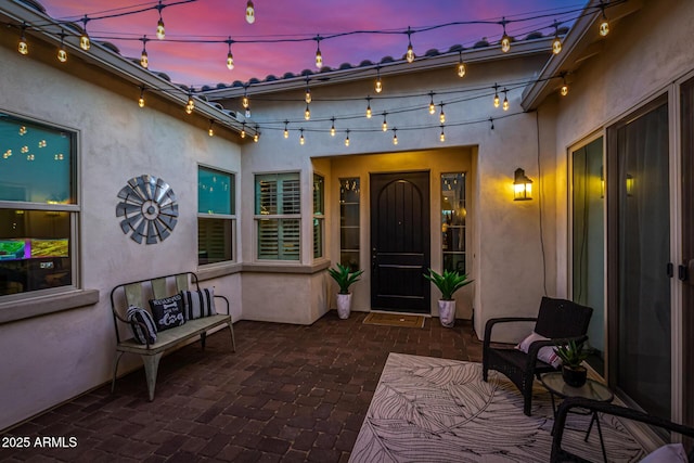 doorway to property featuring a patio area and stucco siding