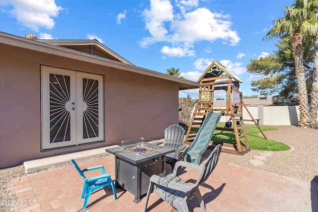 view of patio / terrace with an outdoor fire pit and a playground