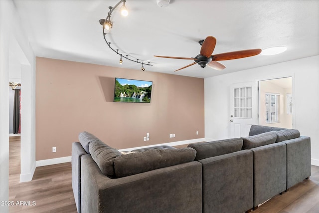 living room with hardwood / wood-style flooring, track lighting, and ceiling fan