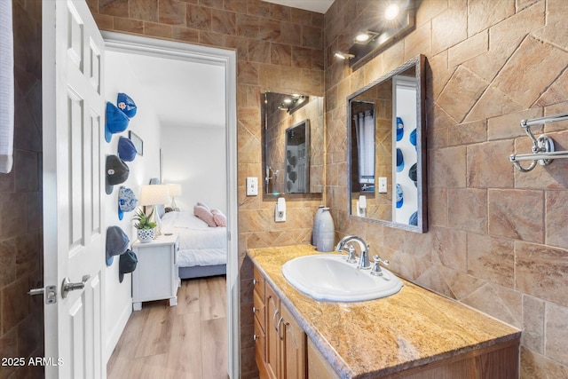 bathroom with vanity, hardwood / wood-style floors, decorative backsplash, and tile walls