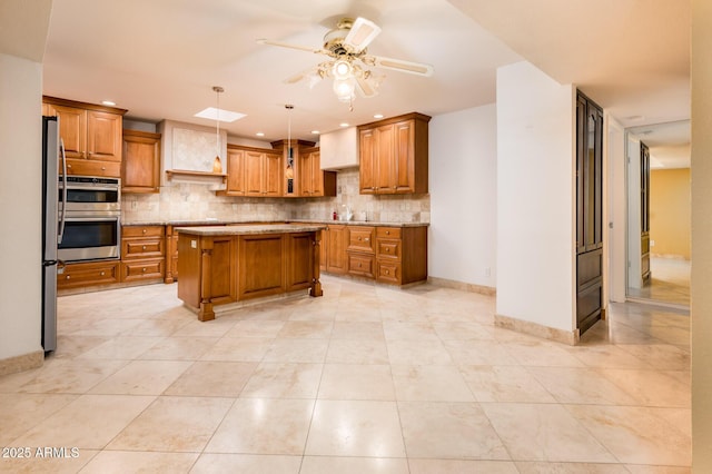 kitchen with stainless steel appliances, a center island, hanging light fixtures, and backsplash