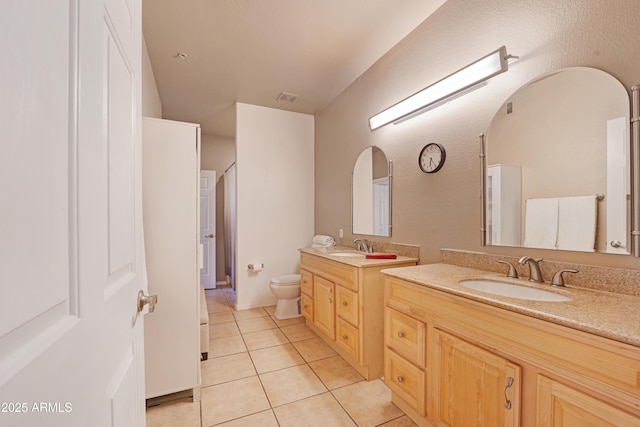 full bathroom featuring a sink, toilet, tile patterned floors, two vanities, and visible vents