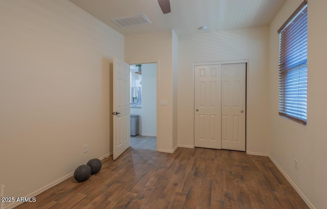 unfurnished bedroom featuring ceiling fan, dark hardwood / wood-style floors, and a closet