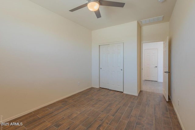 unfurnished bedroom with dark hardwood / wood-style floors, ceiling fan, and a closet