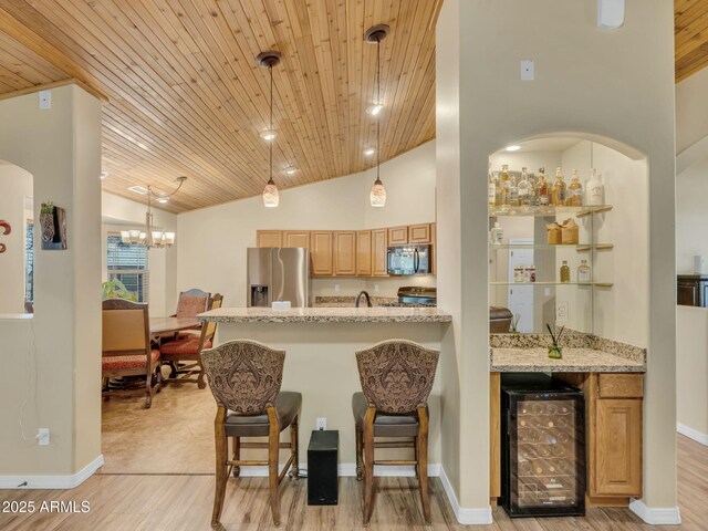 490 E Twelve Oaks Dr, Flagstaff, AZ 86005 - kitchen with stainless steel fridge, black microwave, wine cooler, wood ceiling, and stove