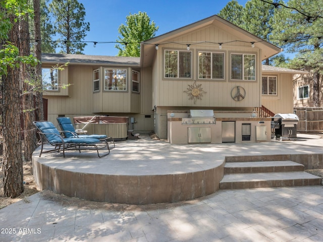 490 E Twelve Oaks Dr, Flagstaff, AZ 86005 - back of property with a hot tub, a patio, roof with shingles, and an outdoor kitchen