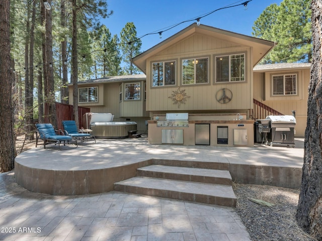490 E Twelve Oaks Dr, Flagstaff, AZ 86005 - back of property with a patio area, exterior kitchen, and a hot tub