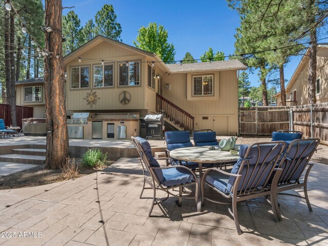 490 E Twelve Oaks Dr, Flagstaff, AZ 86005 - rear view of property featuring a patio area, a hot tub, outdoor dining space, stairway, and exterior kitchen